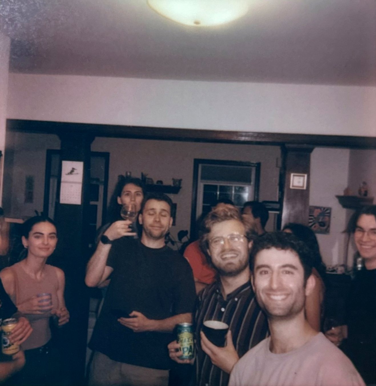 Members with drinks in a Glover Park living room during a Kasumi Club tasting